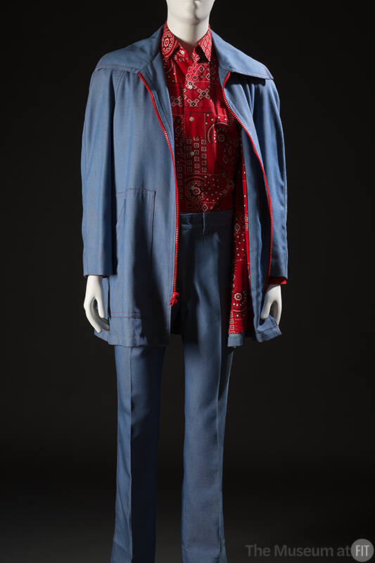 Man’s light blue denim leisure suit ensemble with red zipper on jacket and red, black and white…
