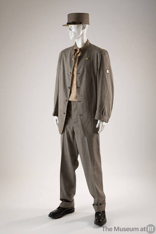 Man’s grey prison uniform of button front stand collar jacket, matching pants, flat top hat wit…