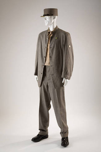 Man’s grey prison uniform of button front stand collar jacket, matching pants, flat top hat wit…
