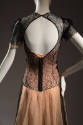 Black lace shirt with circular cut out back over peach pink evening slip dress