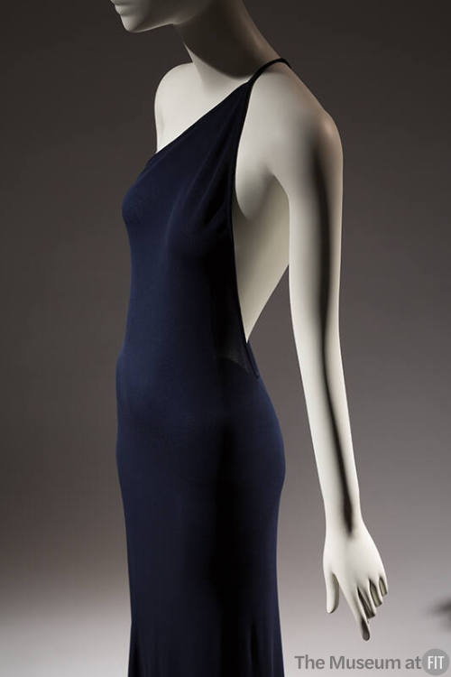 ¾ view of navy blue one shoulder evening dress with thin spaghetti strap