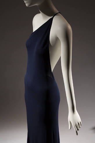 ¾ view of navy blue one shoulder evening dress with thin spaghetti strap
