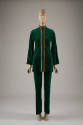 Green pantsuit of tunic jacket with stand collar and gold metallic ribbon and braid edging and …
