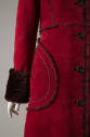 Detail view of dark red coat showing spotted fur trim on cuff and around large rounded patch po…