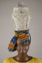 Detail view of wicker basket hat showing green, orange, black, red and white Kente cloth sash t…