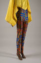 Detail view of stretch pants showing blue, green, orange, red and yellow Kente cloth design