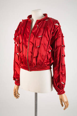 Red bomber style jacket with small diagonal slashes throughout and zipper front