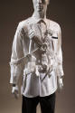 Man’s white oxford style shirt with multiple buckled straps overtop and linked with two front r…
