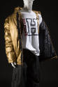 Gold puffer jacket over white Hilfiger logo t-shirt and black pants