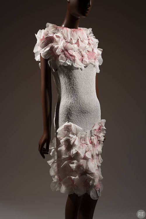 White dress with white and pink rosettes at neckline and bottom of skirt 