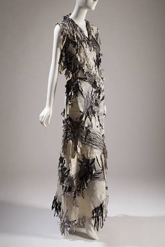 Black and white sleeveless floor length dress with woven sections and fringe