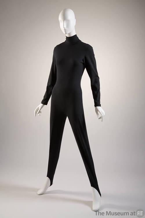 Black turtleneck catsuit with long sleeves, tapered leg with stirrup