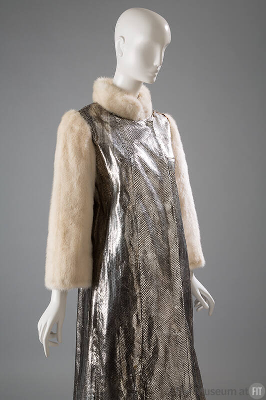 Detail of metallic silver snakeskin coat with white fur collar and long sleeves