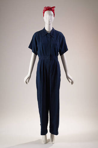 Blue denim short sleeve jumpsuit, covered placket front and breast pocket