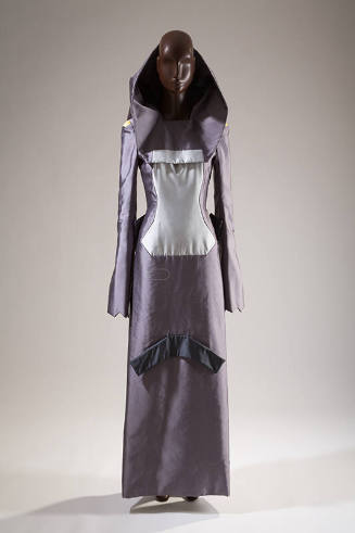 Grey floor length gown with structured open back hood, long angled sleeves, large light grey ce…