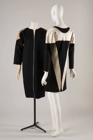 Black collarless coat with quilted gold wing motif at shoulders; coordinating long sleeve dress…
