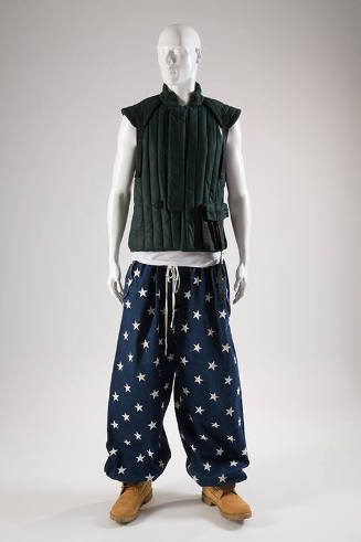Dark teal green padded vest with vertical quilting; loose, navy pants with white star pattern; …