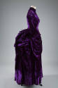 Purple dress with floor length bustle back skirt with draped and pleated puffs at hips