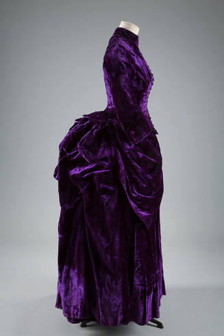 Purple dress with floor length bustle back skirt with draped and pleated puffs at hips