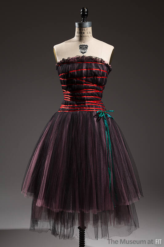 Black semi sheer strapless dress with pink under layer, criss cross straps across bodice, and b…