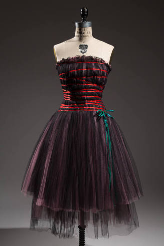 Black semi sheer strapless dress with pink under layer, criss cross straps across bodice, and b…