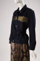¾ view of dark blue denim jacket ensemble showing metallic gold band across chest, button front…