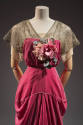 Closer view of dark pink evening dress showing gold metallic lace upper bodice and short sleeve…
