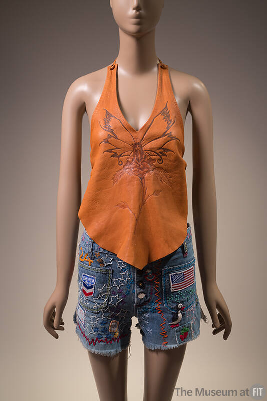 Orange leather halter top with burnished fairy and flower design and denim cut off shorts cover…