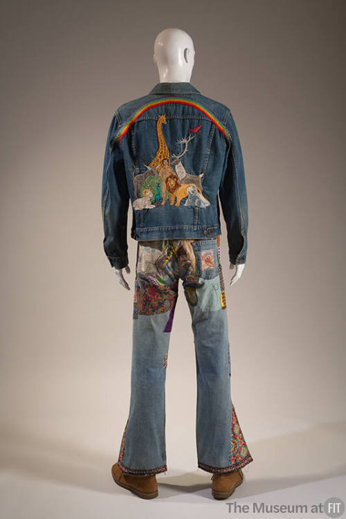 Back view of man’s blue denim jacket embroidered with man, animals and rainbow and bell bottom …