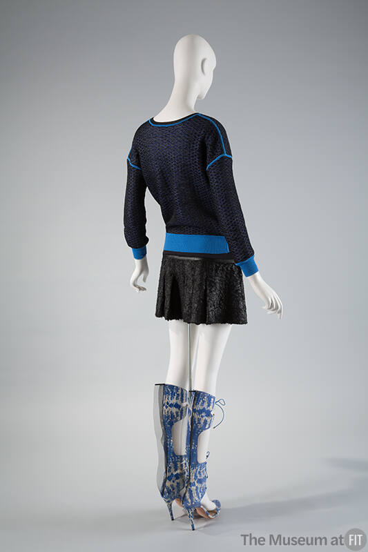 Back view of blue mesh sweatshirt with royal blue trim, black pleated mini skirt and blue and w…