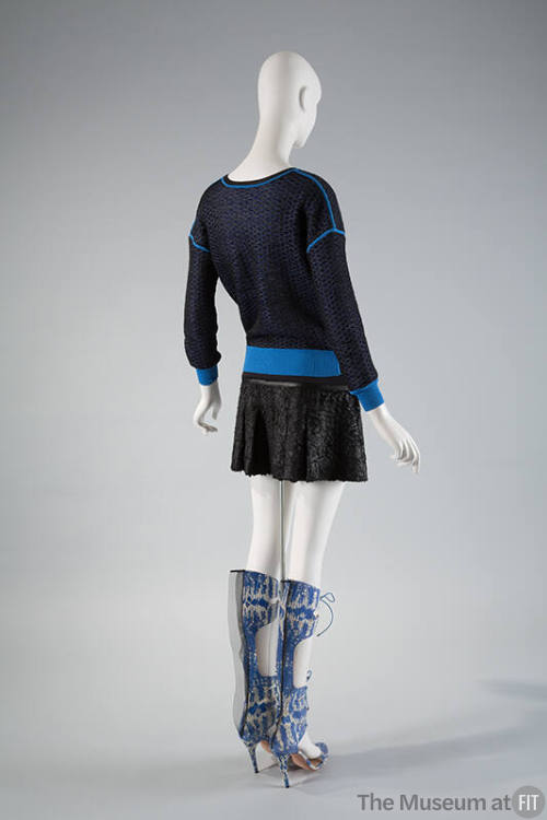 Back view of blue mesh sweatshirt with royal blue trim, black pleated mini skirt and blue and w…