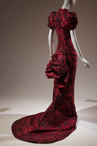 Back view of red and black feather printed fitted evening dress with short oversize puff sleeve…