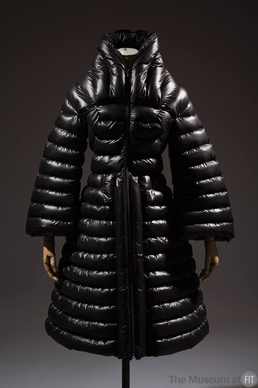 Black puffer coat with horizontal quilting, stand collar, bell sleeves, fitted waist and flared…