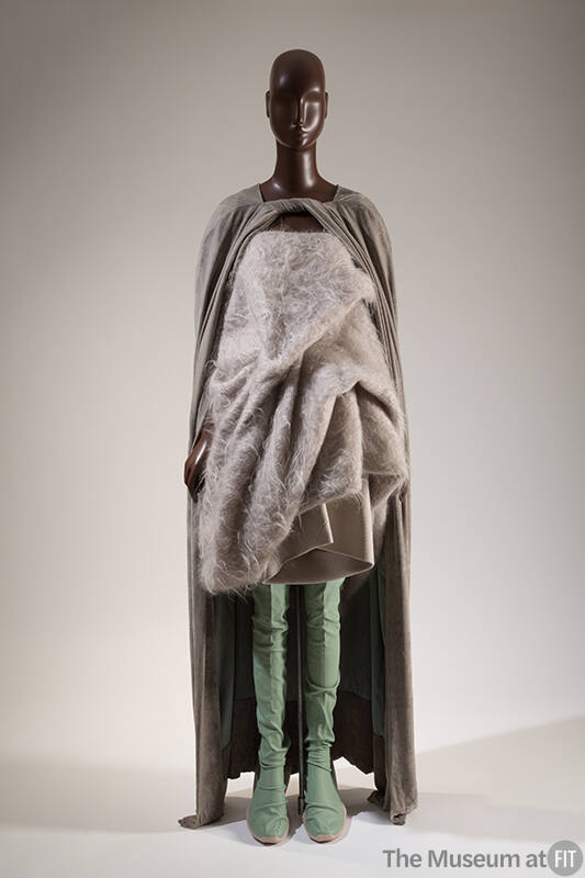 Ensemble of pale grey mohair top with gathers and folds, green floor length cape and scrunched …