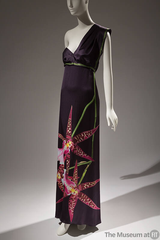 Dark grey one shoulder floor length dress with empire waist trimmed in green and oversize pink …
