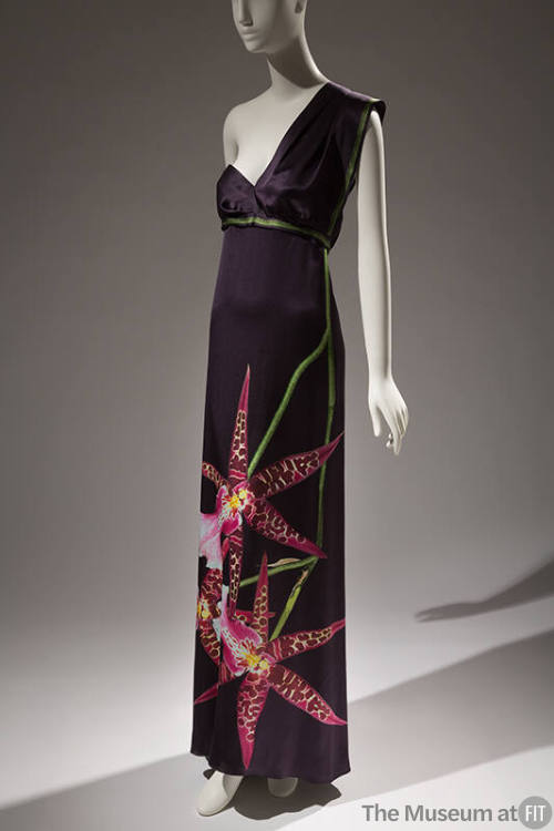 Dark grey one shoulder floor length dress with empire waist trimmed in green and oversize pink …