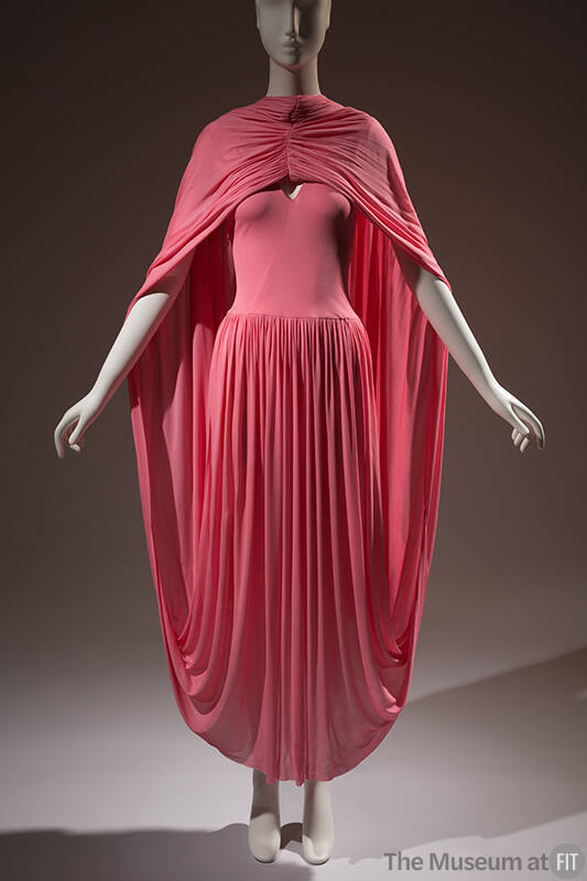 Pink dress with a gathered skirt that extends from behind the ankle and back over the shoulders…