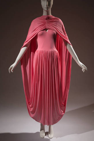 Pink dress with a gathered skirt that extends from behind the ankle and back over the shoulders…