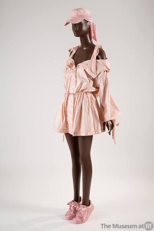 Pink nylon jacket with off-the-shoulder sleeves and bow tied camisole straps and gathered draws…