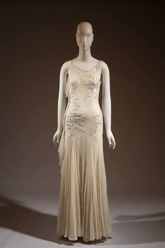Ivory floor length sleeveless evening dress with white floral embroidery throughout bodice and …