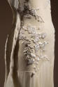 Detail view of ivory evening dress showing white floral embroidery at left hip