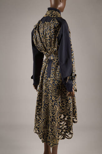 Back view of navy blue trench coat with gold metallic floral lace overlay throughout and high-l…