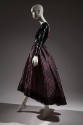 Side view of evening dress with black sequined long sleeve bodice and pink, white and black pla…