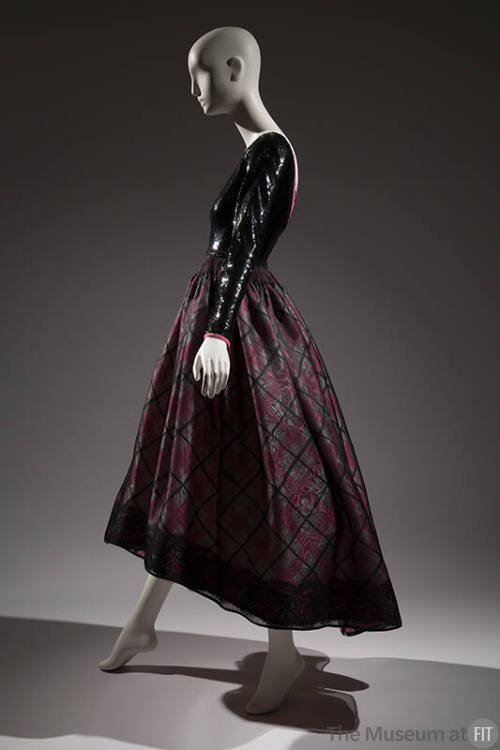 Side view of evening dress with black sequined long sleeve bodice and pink, white and black pla…