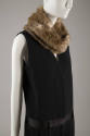 Detail of black sleeveless jumpsuit with satin waistband and faux fur neck warmer 