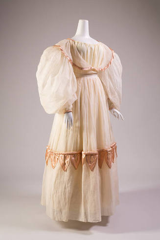 White organdy floor length dress with balloon sleeves, pink trim on collar that extends over bo…