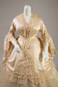 Detail view of cream silk satin dress shown with alternate bodice of v-neck trimmed with lace a…