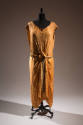 Orange cap sleeve evening dress with woven gold lamé texture, draping in center front secured w…