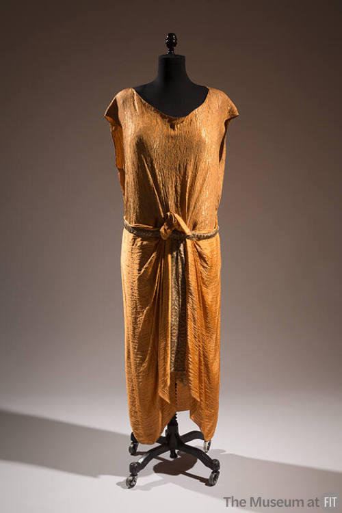 Orange cap sleeve evening dress with woven gold lamé texture, draping in center front secured w…