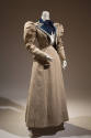 Natural linen summer suit of jacket with puffed shoulders and navy blue lapels, floor length sk…